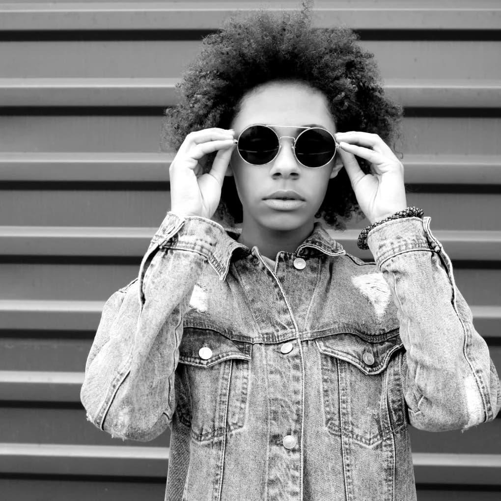 Campaña de lentes de sol oscuros y redondos, en blanco y negro. Ópticas Goodwill.